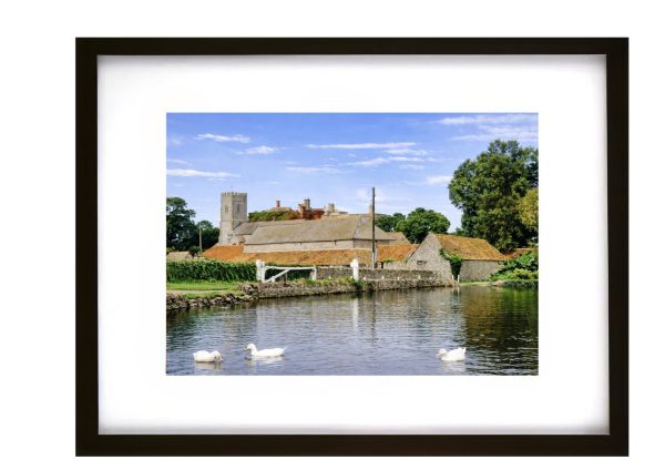 East Quantoxhead Somerset village church and historic buildings beside pond with ducks