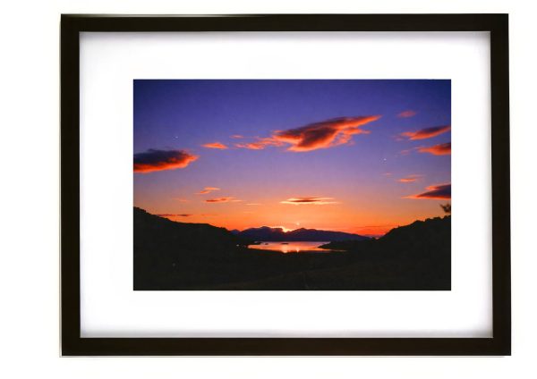 Sunset near Oban Scotland with silhouetted Highland hills and coastal waters