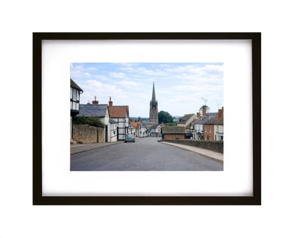 Historic street view of Weobley Herefordshire with black and white timber framed houses and church spire